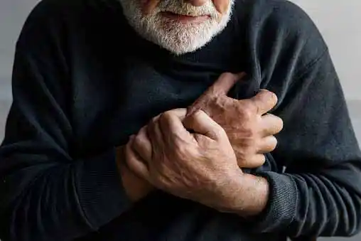 old man covering his chest because of pain